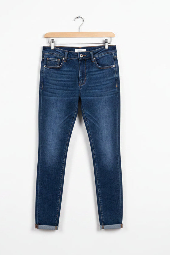 Blue jeans on a hanger against a white background