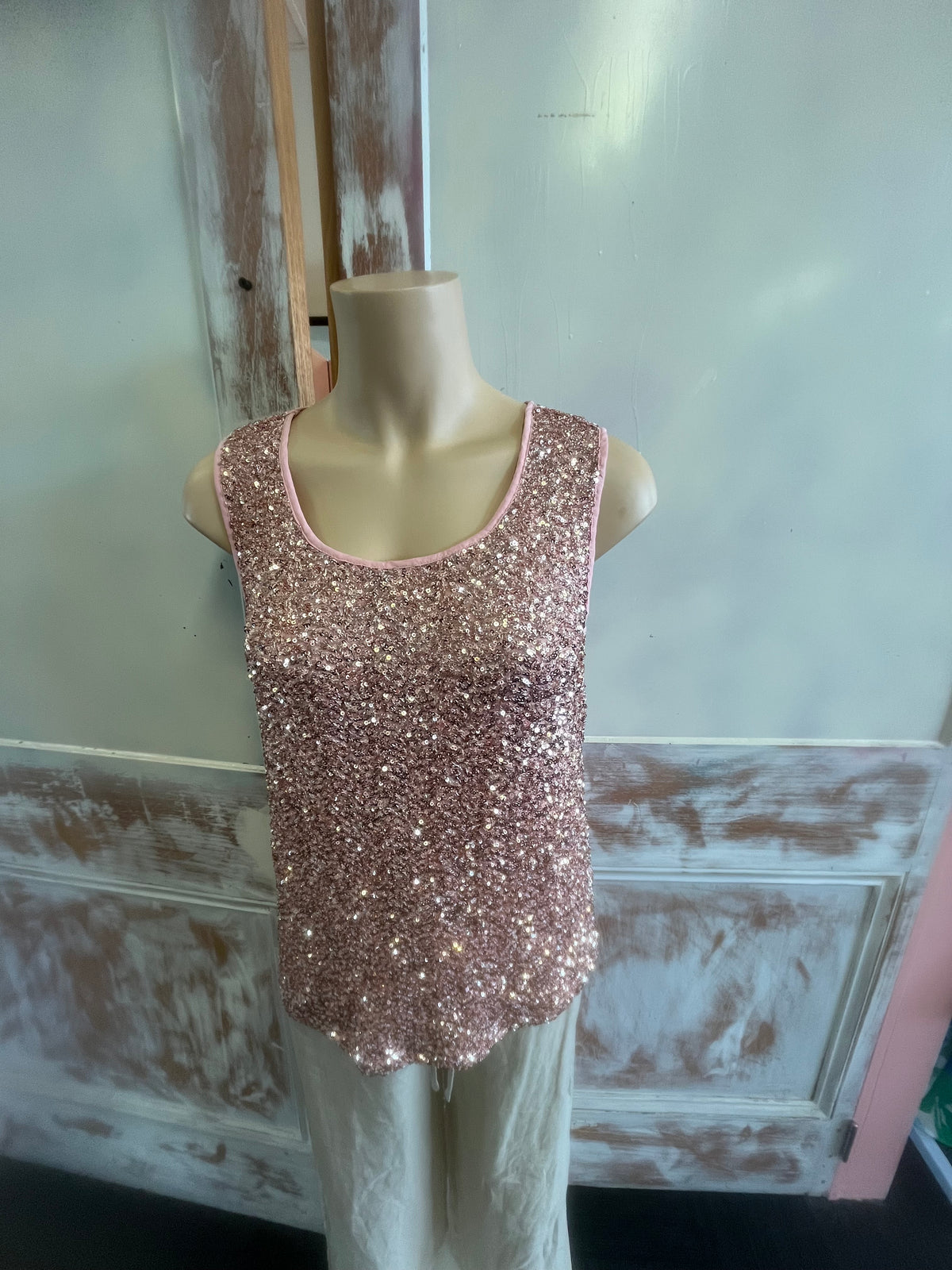 Sparkly pink shoe on a mannequin against a rustic wooden background