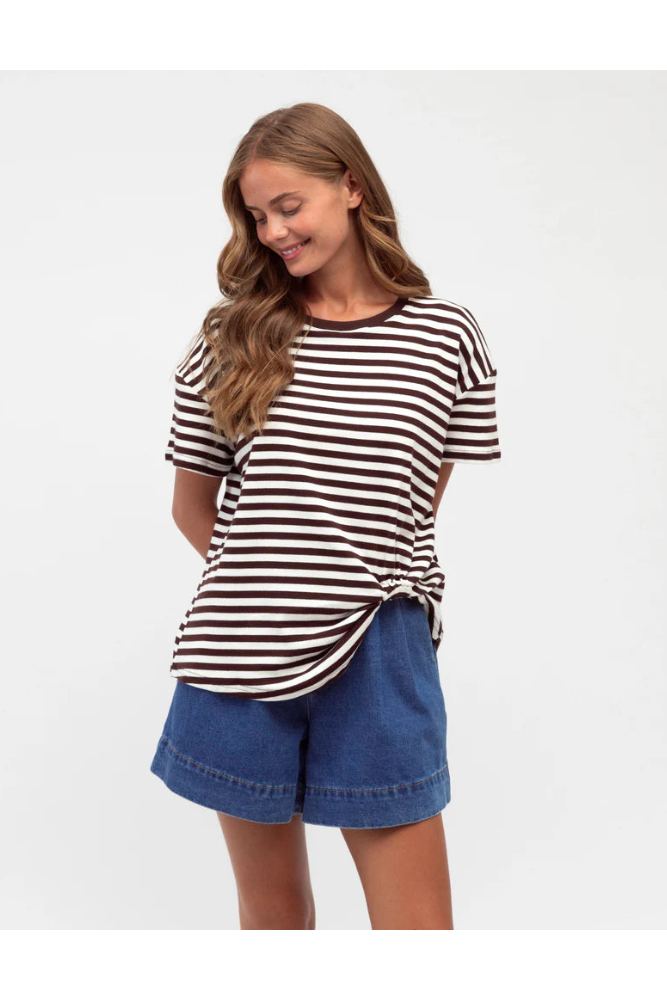 Woman wearing a striped shirt and denim shorts on a white background
