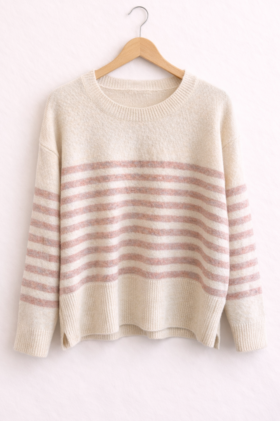 Striped sweater on a hanger against a white background