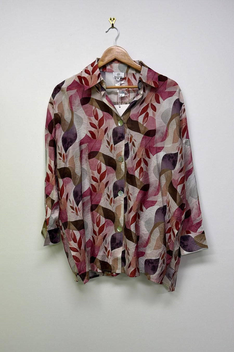 Floral patterned jacket on a hanger against a white wall