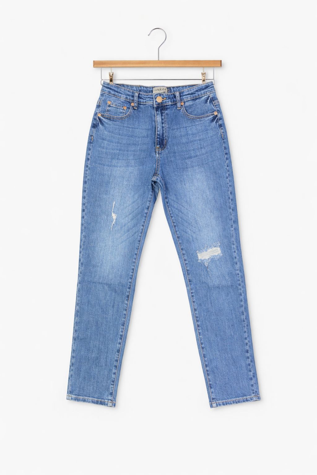 Blue jeans on a hanger against a white background